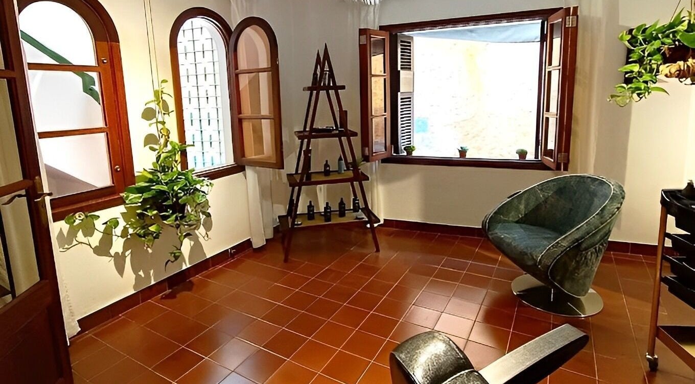 Chic, rustic interior of Barberia Santanyi Man Escape with plants and comfy chairs in Santanyí, Illes Balears, ES.