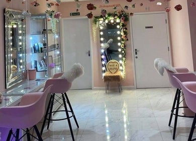 Chic vanity area at HMAKE in Stockport, England, GB, with pink chairs and floral decor.