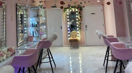 Chic vanity area at HMAKE in Stockport, England, GB, with pink chairs and floral decor.