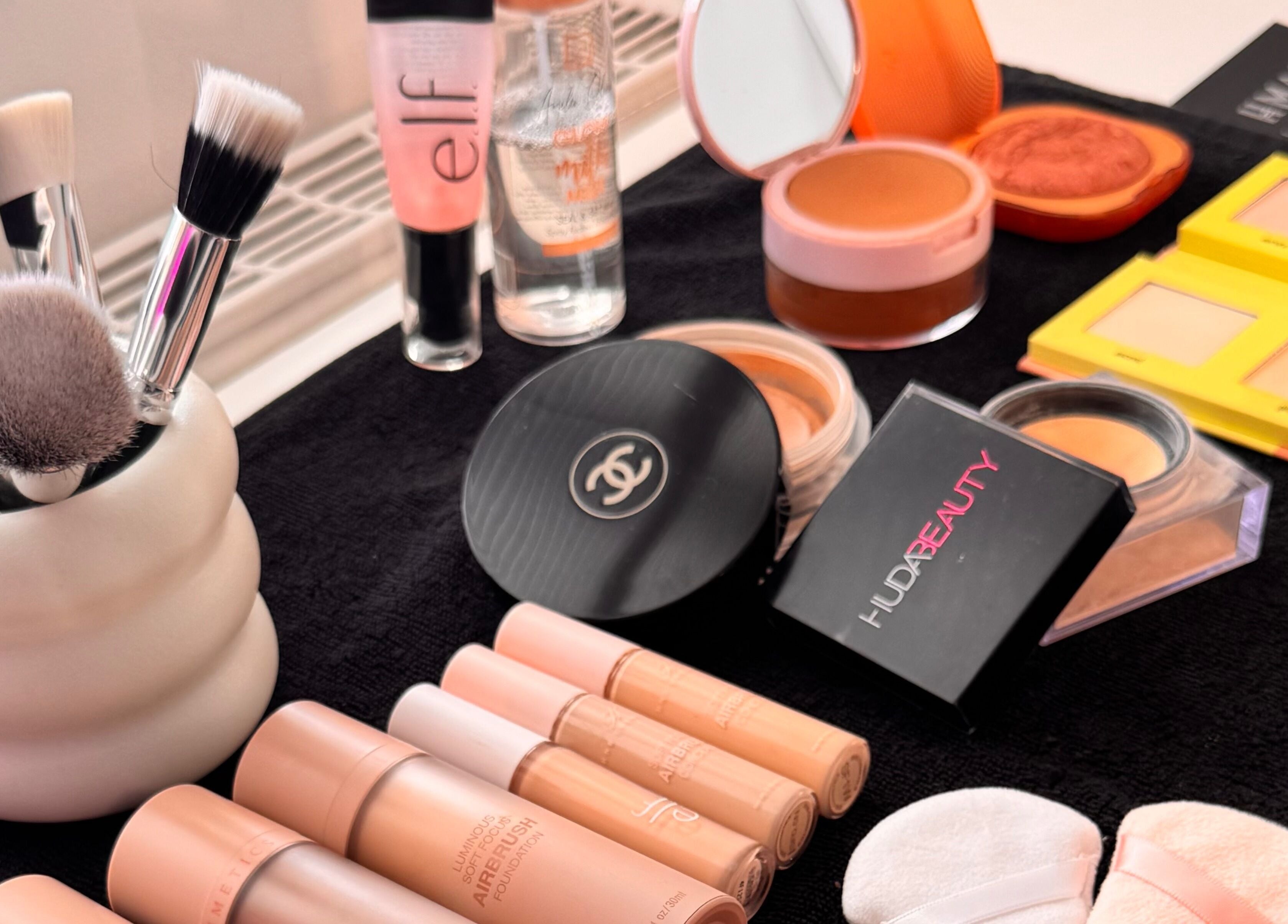 Hmake Stockport beauty products including makeup brushes, powders, and cosmetics displayed elegantly.