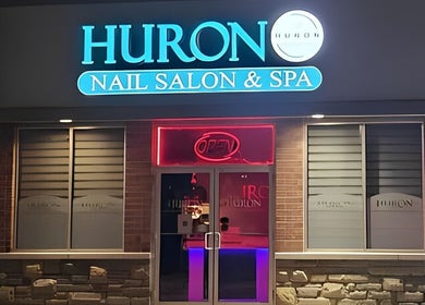 Front view of Huron Nail Salon in Kitchener, Ontario, CA with bright signage and open sign.