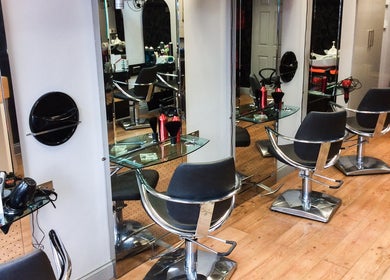 The Salon in Wigan, GB features modern styling chairs and mirrors for a high-end beauty experience.