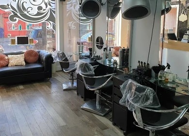 Modern interior of The Salon in Wigan, GB featuring stylist chairs, mirrors, and elegant décor.