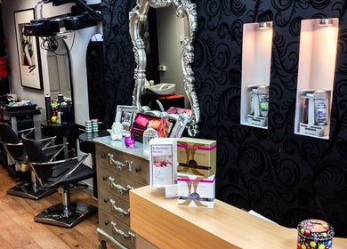 Elegant interior of The Salon, Wigan, GB featuring chic styling chairs and ornate mirrors.