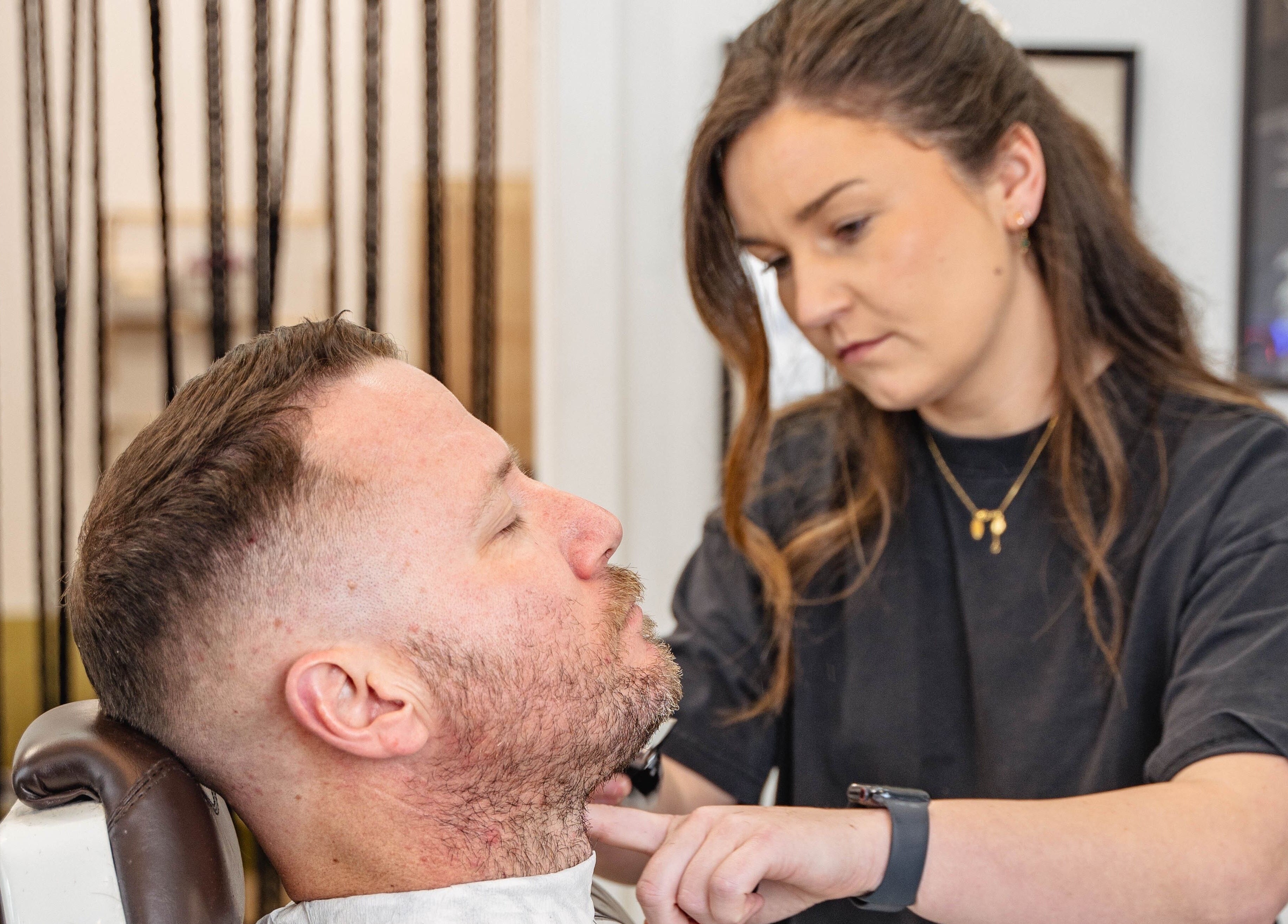 Stylist trims a client's beard at Dark and Stormy Barber Collective, Bendigo, Victoria, AU.