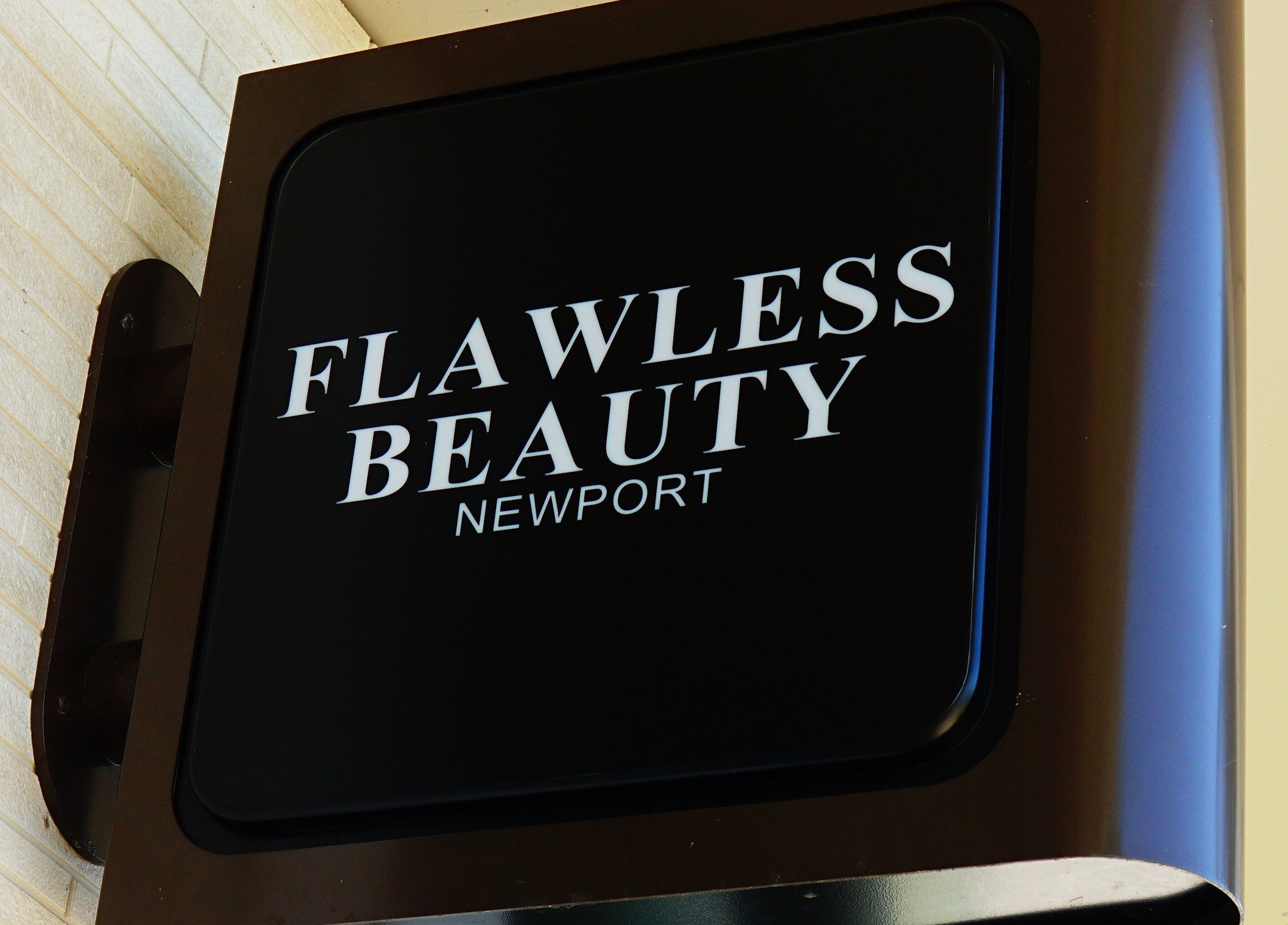 Entrance sign of Flawless Beauty Newport, located in Newport, Queensland, AU with elegant black and white design.