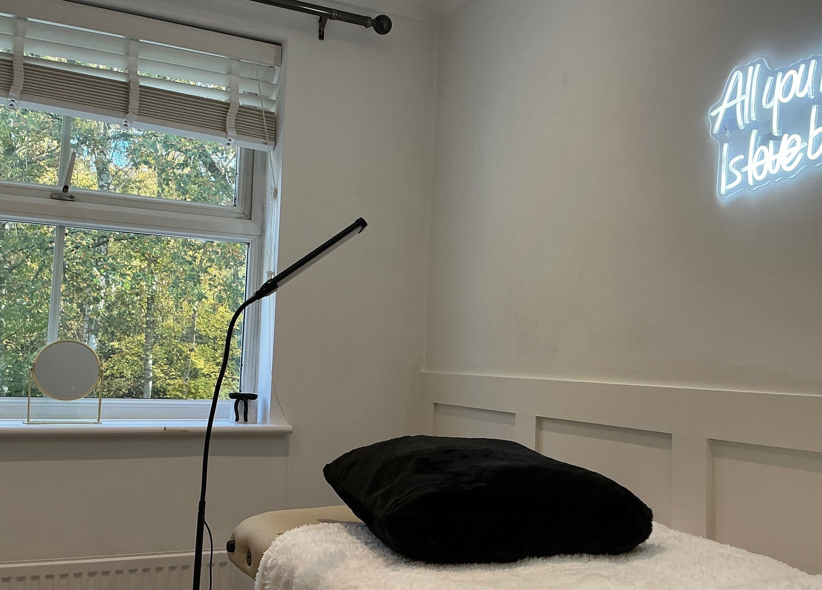 Cozy interior of Brows by Lauren in Lincoln, England, GB, featuring a neon sign and comfortable treatment bed.