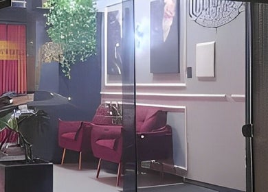 Interior sofisticado do Kurotake Barbershop, Paraná, Paraná, BR, com cadeiras vermelhas e decoração moderna.