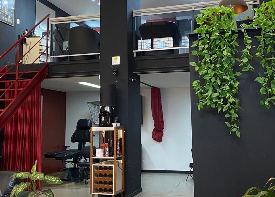 Interior elegante do Kurotake Barbershop, Paraná, Paraná, BR. Escada vermelha e decoração verde.