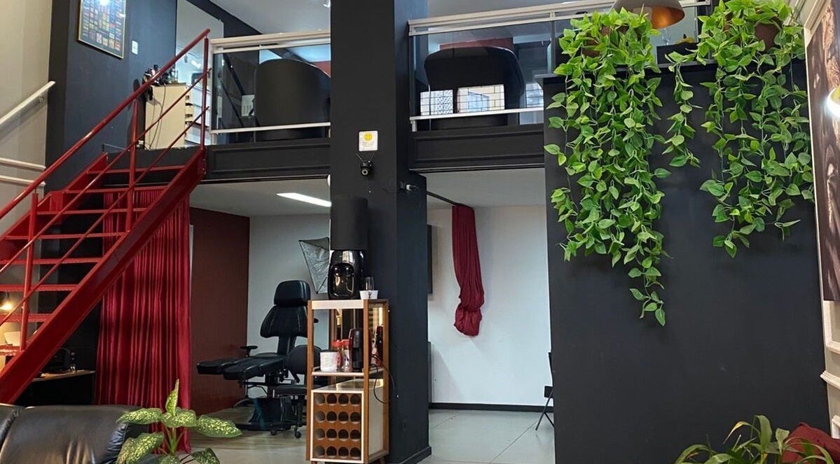 Interior elegante do Kurotake Barbershop, Paraná, Paraná, BR. Escada vermelha e decoração verde.