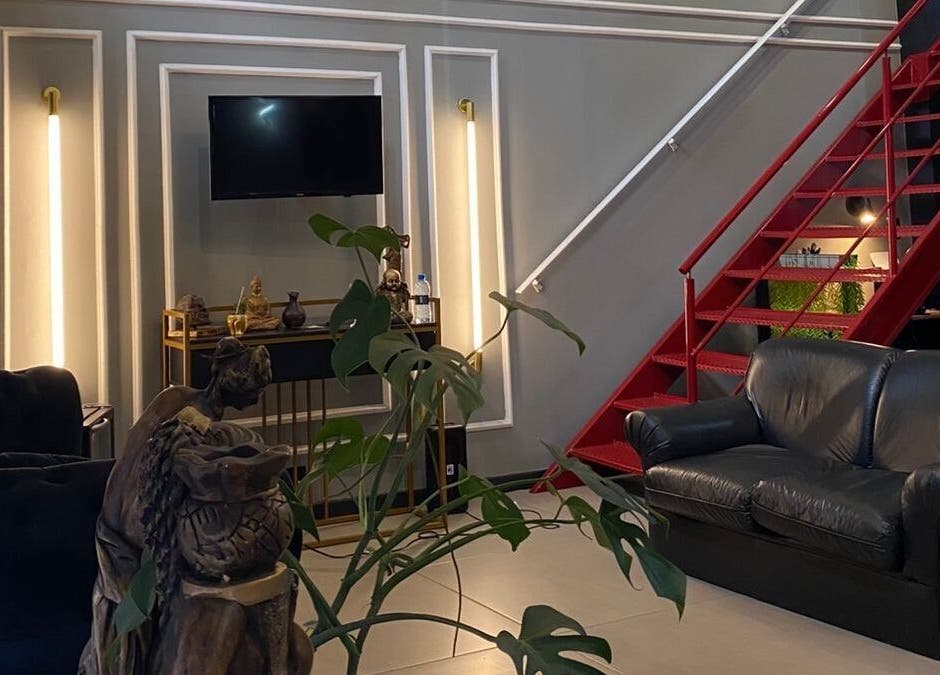 Interior do Kurotake Barbershop em Paraná, Paraná, BR com sofá acolhedor e decoração moderna.