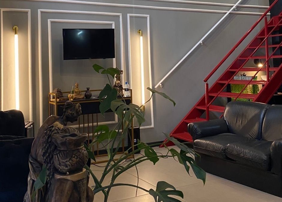 Interior do Kurotake Barbershop em Paraná, Paraná, BR com sofá acolhedor e decoração moderna.