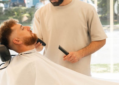 Barber grooming client at KO CUTZ SALON & SPA in Mississauga, Ontario, CA, offering expert beard trimming.