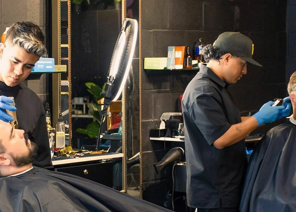Barbers styling hair at Scotch and Fades in Vancouver, British Columbia, CA, showcasing professional grooming.