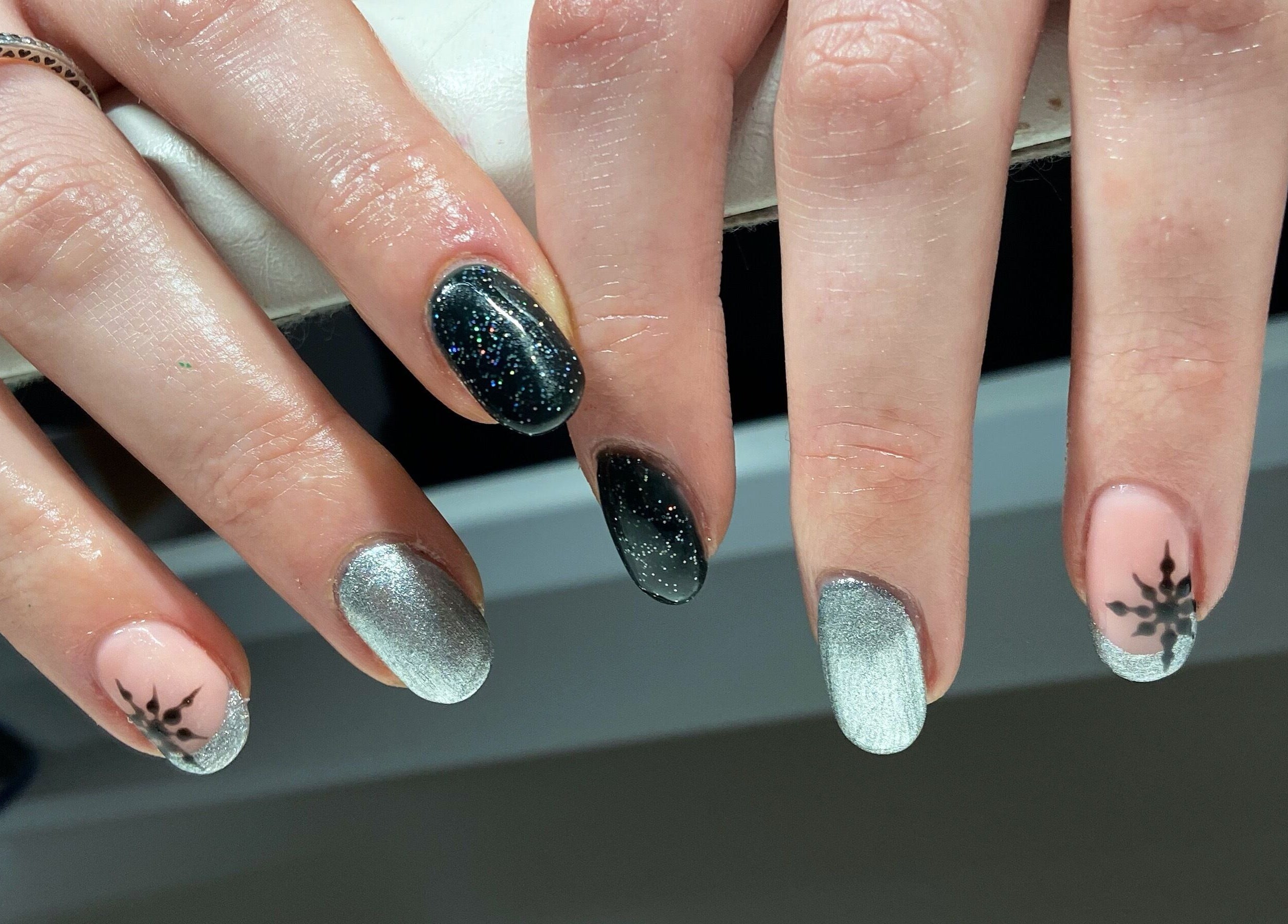 Stylish nail art with metallic and black designs at Nails By Jo in Fremington, England, GB.