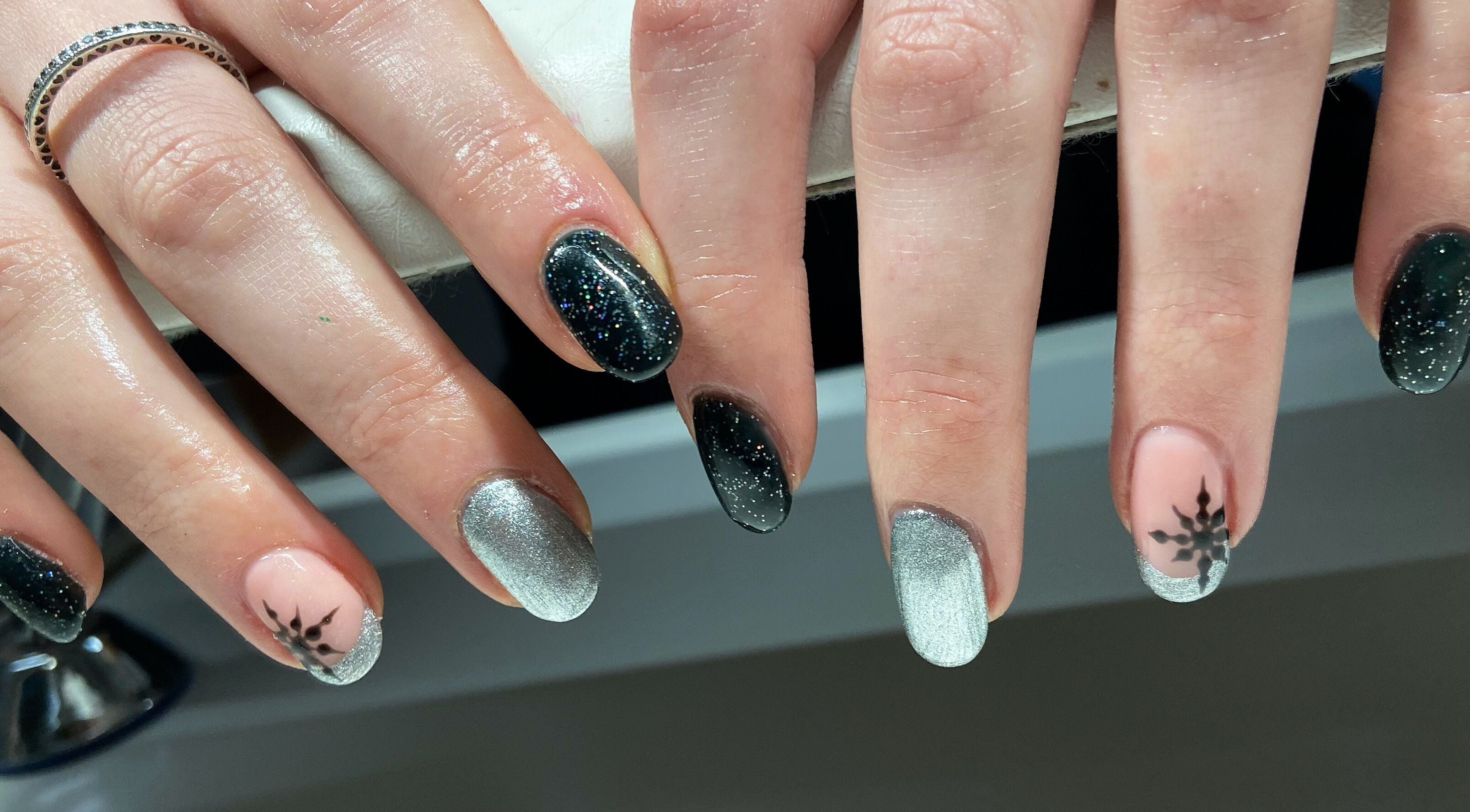 Stylish nail art with metallic and black designs at Nails By Jo in Fremington, England, GB.