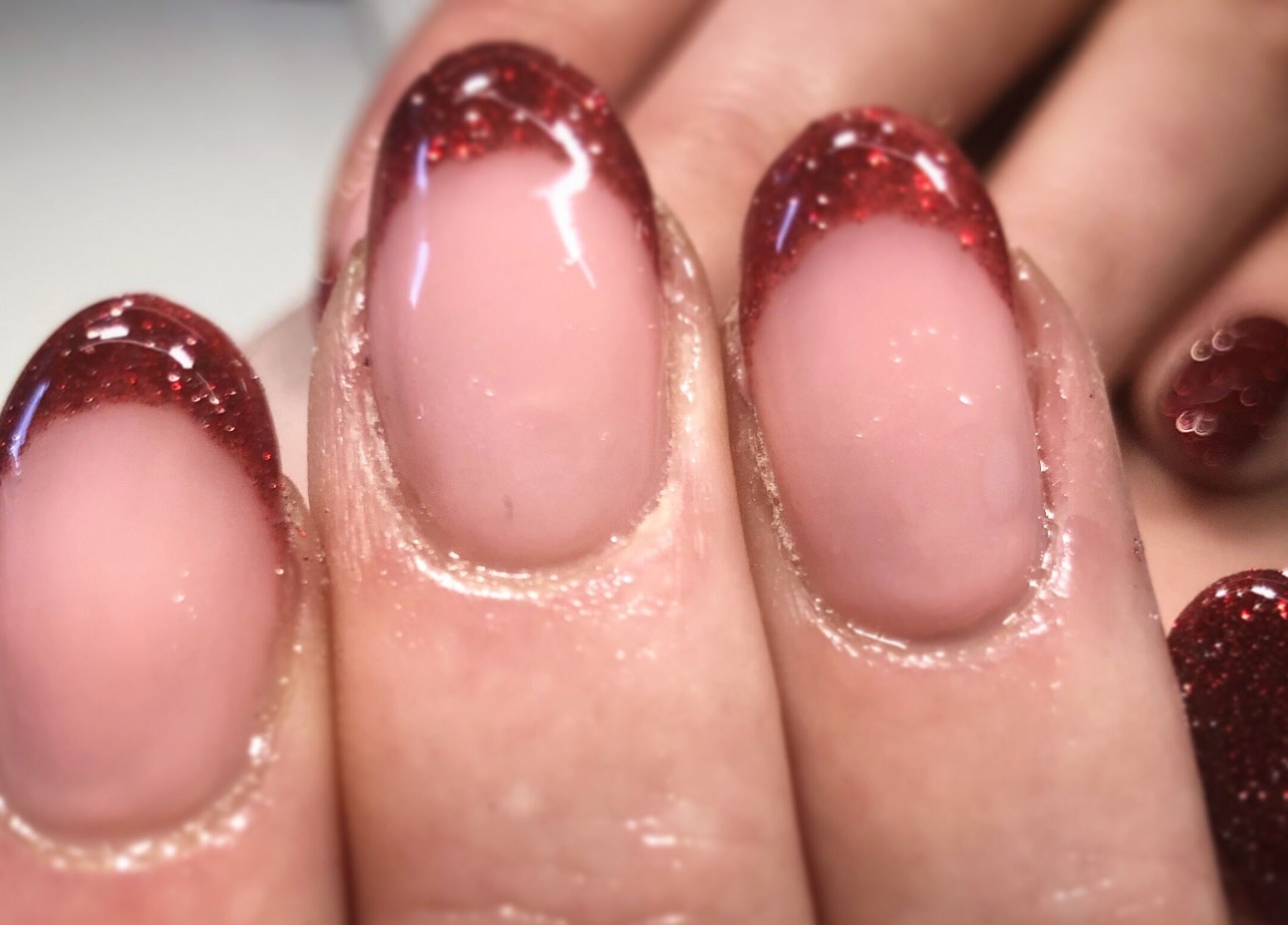 Close-up of glitter red nails at Nails By Jo, Fremington, England, GB, showcasing elegant nail art.