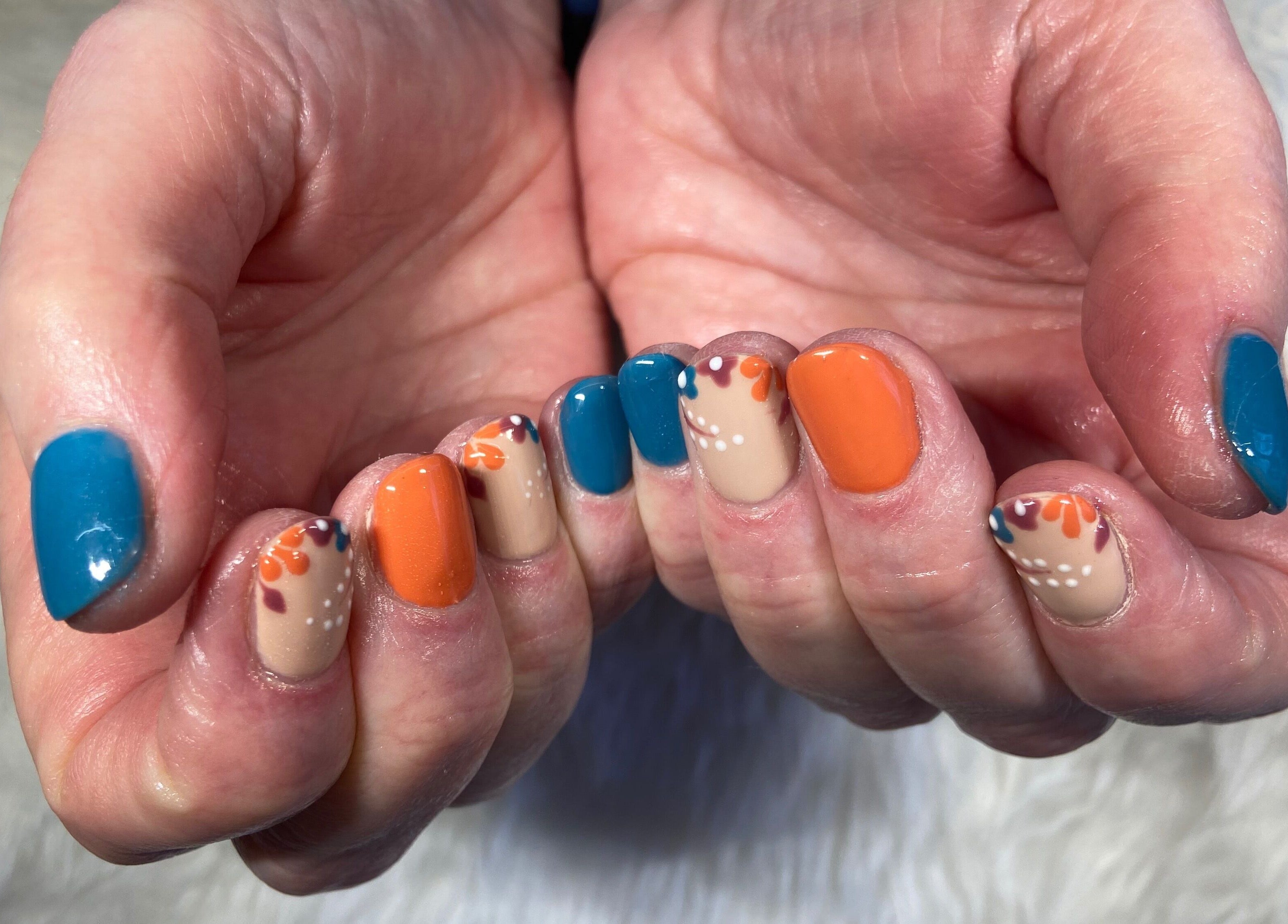 Colorful nail design at Nails By Jo, Fremington, England, GB showcasing blue and orange patterns.