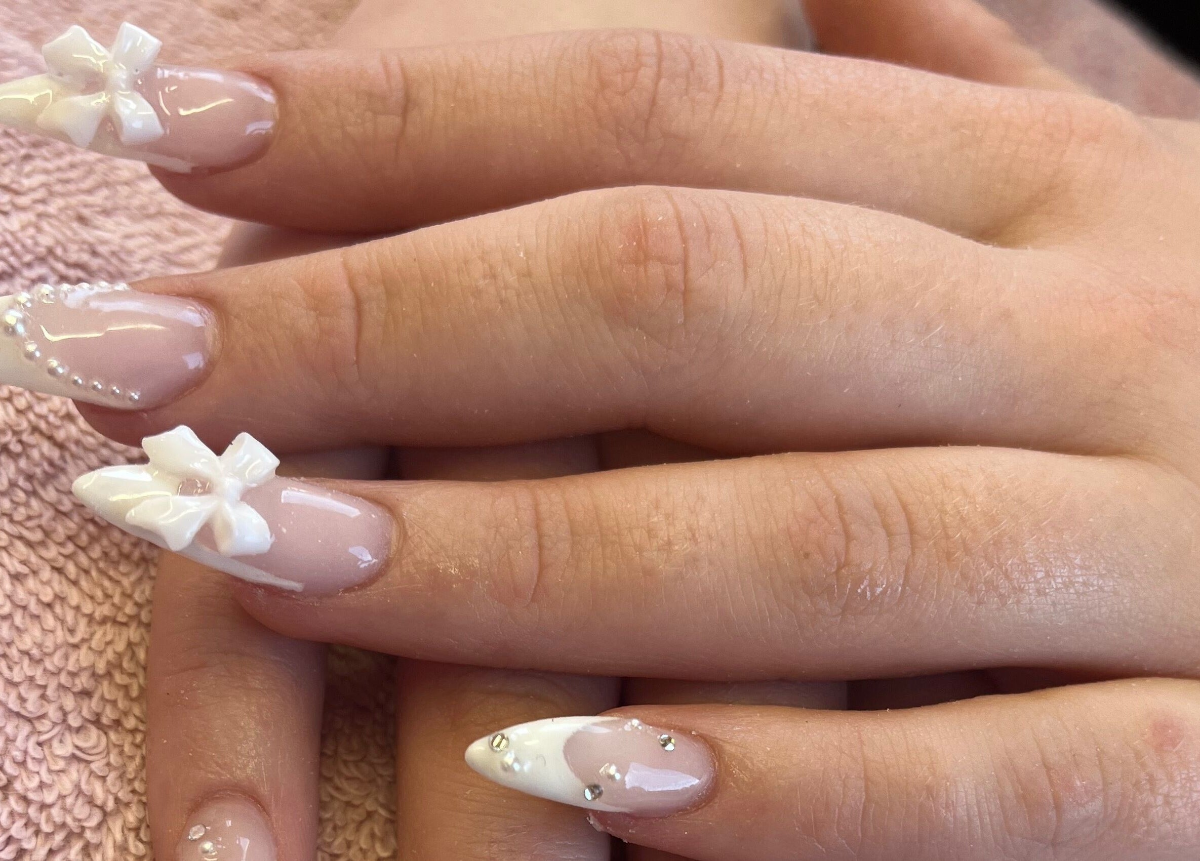 Intricate white nail art with bows at Magpie Nails, Havant, England, GB. Perfect for elegant occasions.