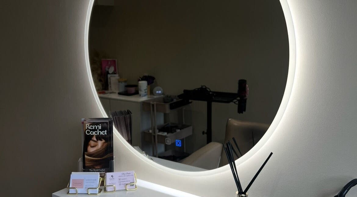Modern salon mirror at Lozza’s Hair, Swanley, England, GB, reflecting sleek design and stylish decor.