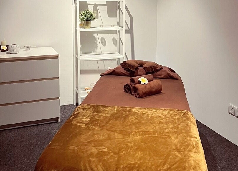 Cozy massage room at The Bae Dazzle, Johor Bahru, Johor, MY with a soft bed and calming candles.