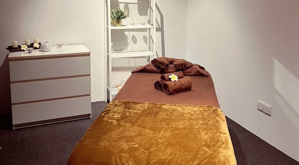 Cozy massage room at The Bae Dazzle, Johor Bahru, Johor, MY with a soft bed and calming candles.