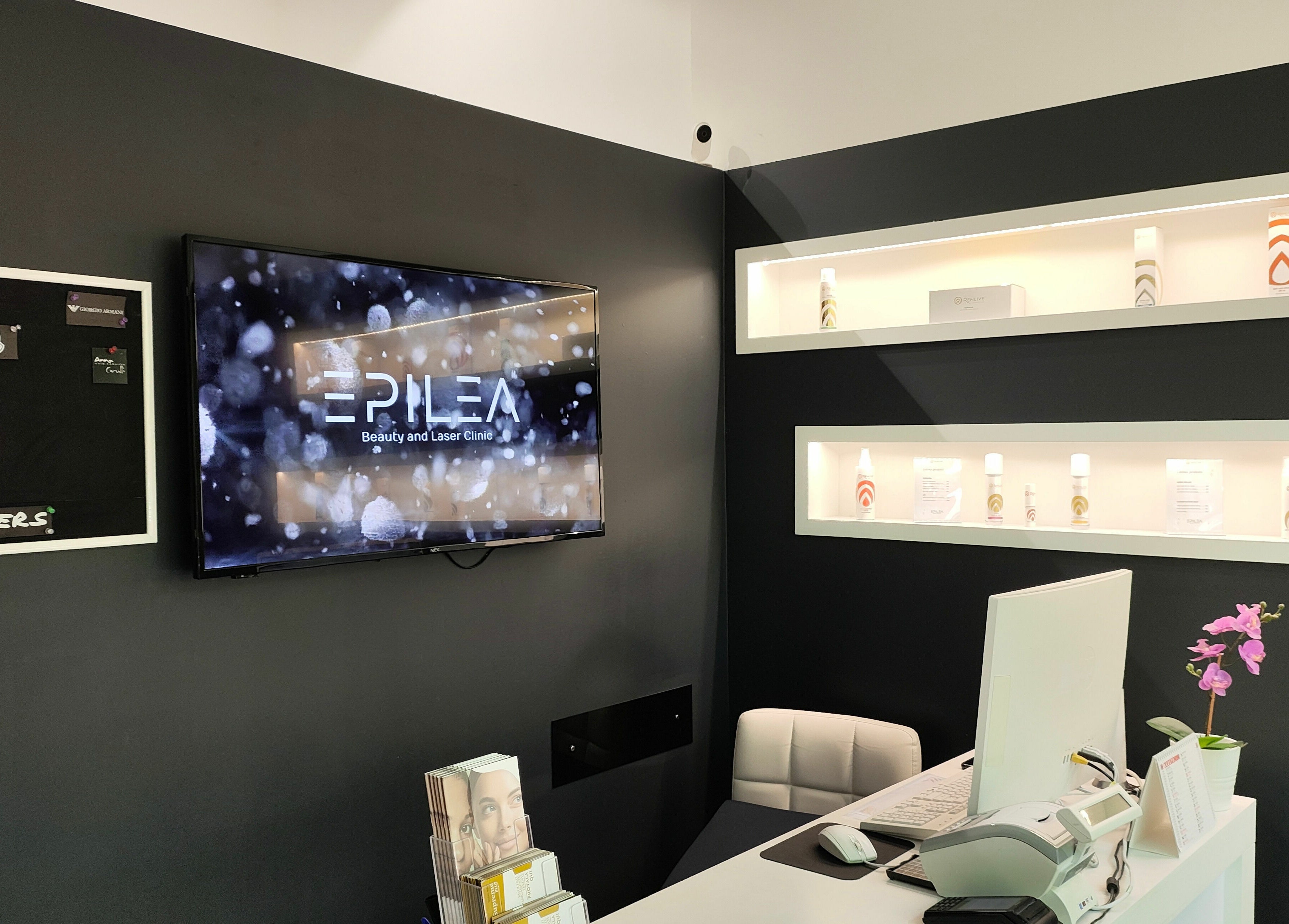 Reception moderna di Epilea Milano, Milano, Lombardia, IT, con parete nera e schermo lucido.