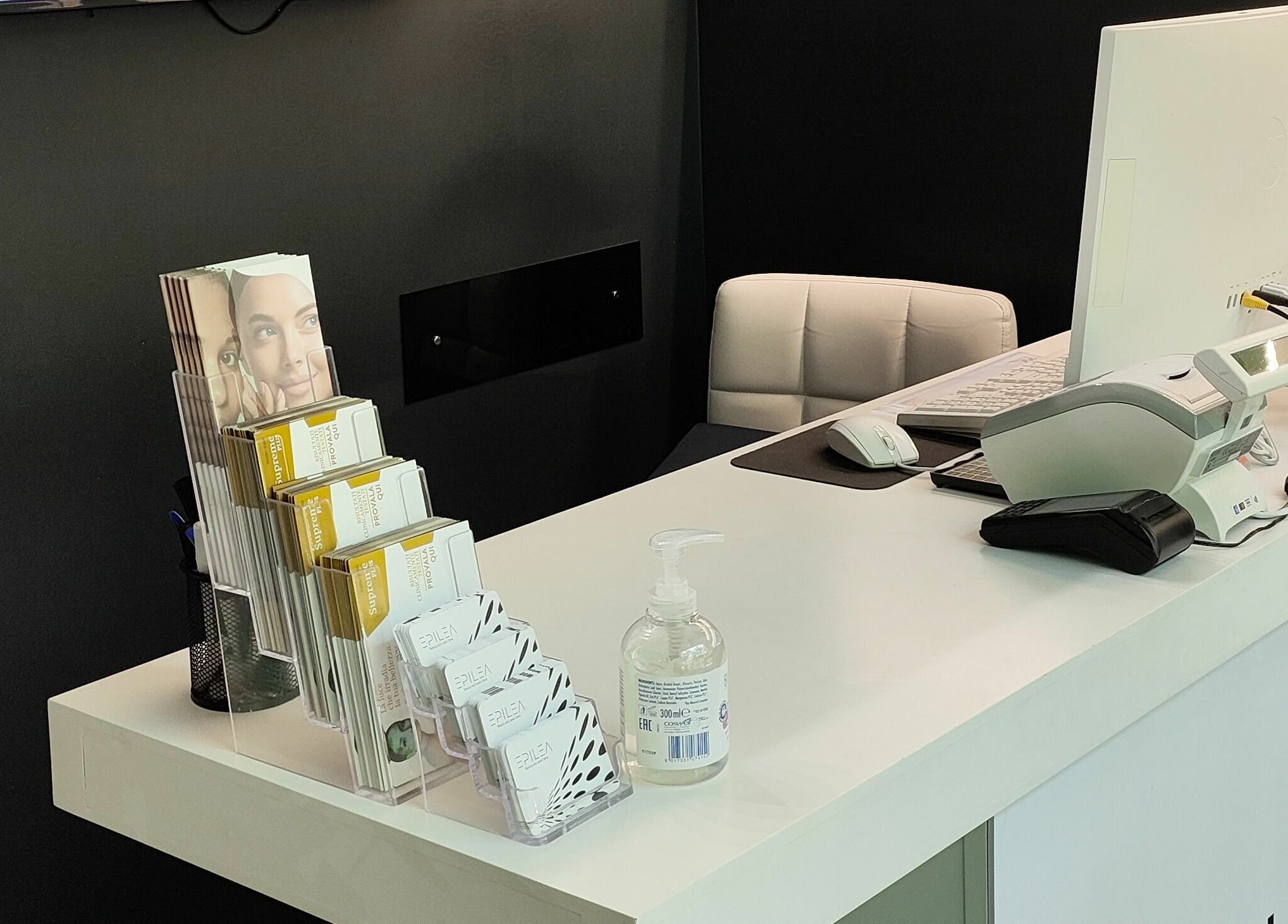 Reception di Epilea Milano, elegante con brochure e igienizzante, situata a Milano, Lombardia, IT.