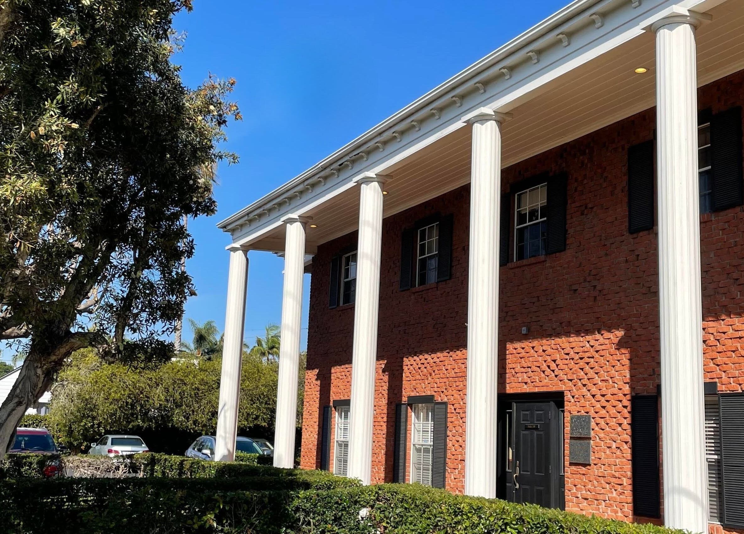 Colonial-style building of San Diego Reiki (Carlsbad) in Carlsbad, California, US under clear blue sky.