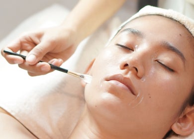 Facial treatment at ULU Beauty Studio, Bali, Bali, ID. Close-up of a relaxed person receiving skincare with a brush.