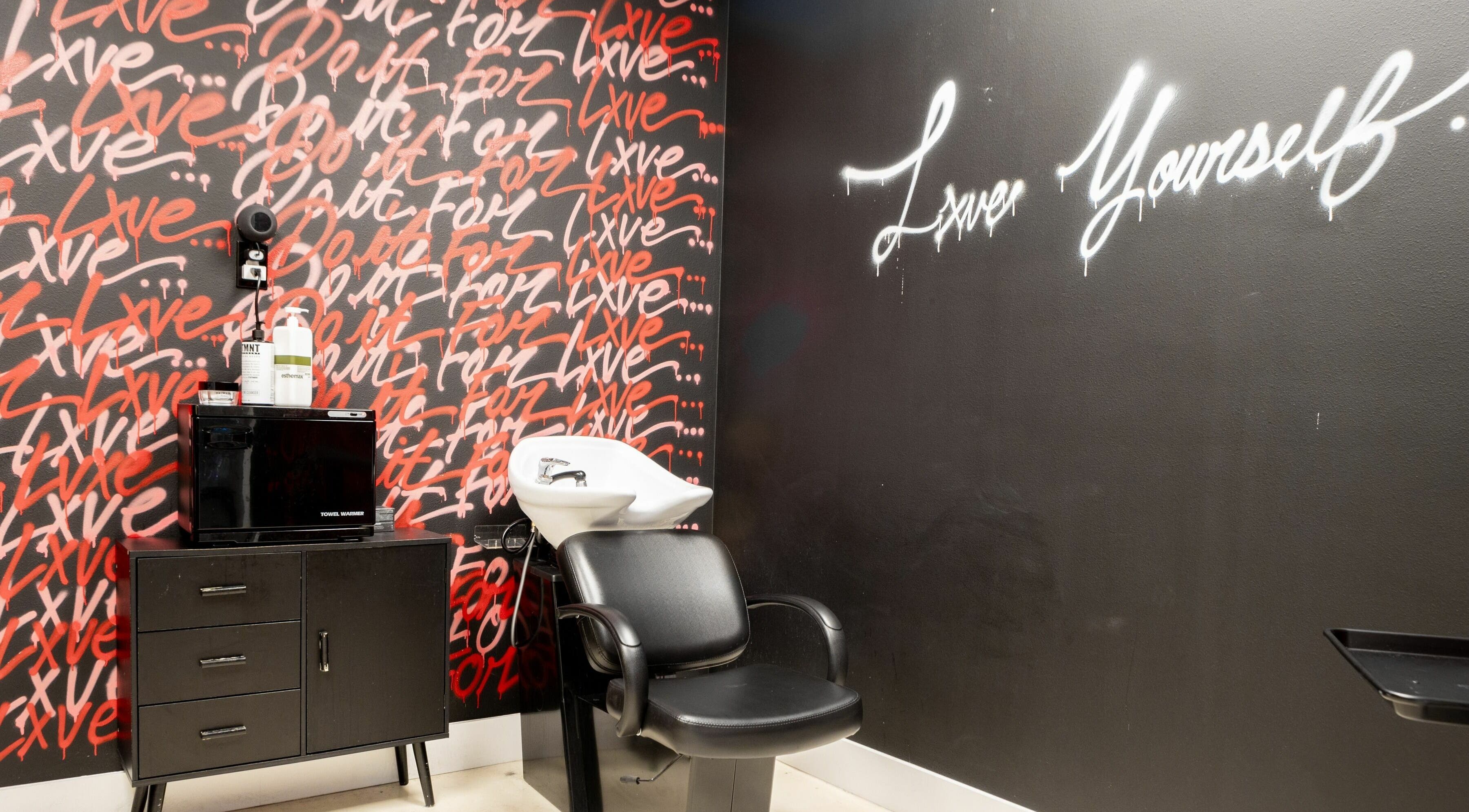 Modern hair washing station at Lxve Studios, Las Vegas, Nevada, US, with artistic wall graffiti.