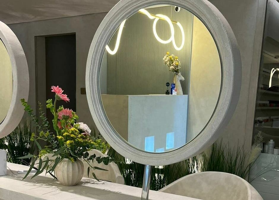 Elegant interior view of Jaw Beauty Salon, Abu Dhabi, AE with round mirror and floral decor.