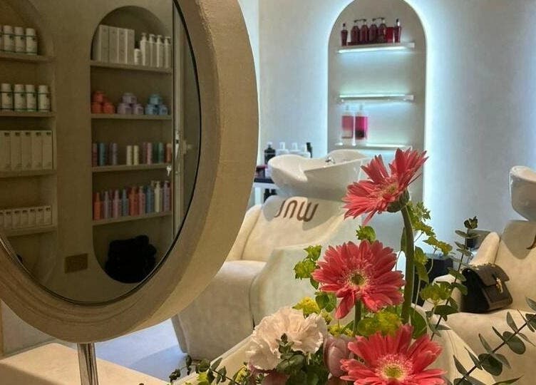 Stylish interior of Jaw Beauty Salon in Abu Dhabi, AE with floral decor and product shelves.