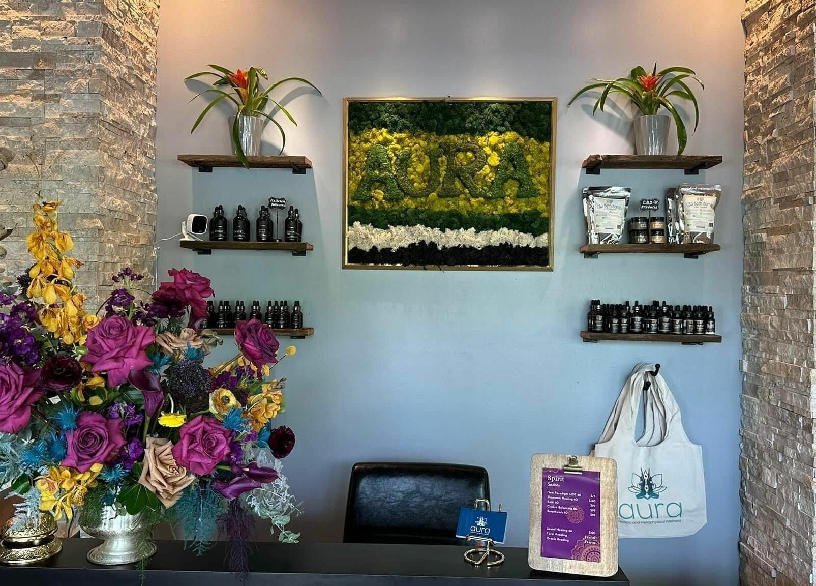 Front desk at Aura Holistic and Metaphysical Wellness in Aurora, Illinois, beautifully decorated with colorful flowers.
