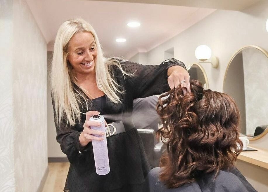Stylist creating curls at The Little Hair Shop, Whittlesey, England, GB. Elegant salon ambiance.