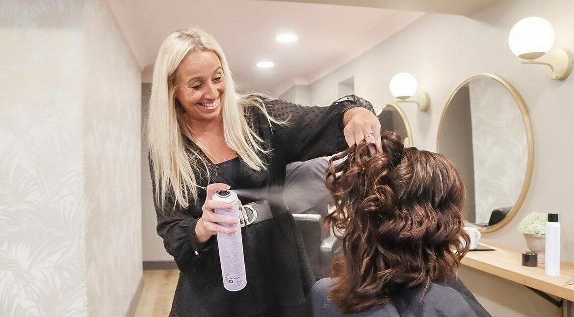 Stylist creating curls at The Little Hair Shop, Whittlesey, England, GB. Elegant salon ambiance.