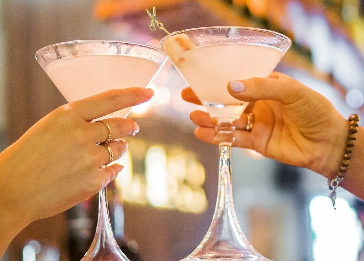 Two cocktails clinking at Blow Bar Bali, Bali, ID, capturing vibrant social ambiance.