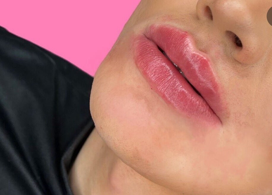 Close-up of enhanced lips at HLC Aesthetics, Abbeymead, England, GB on pink background.