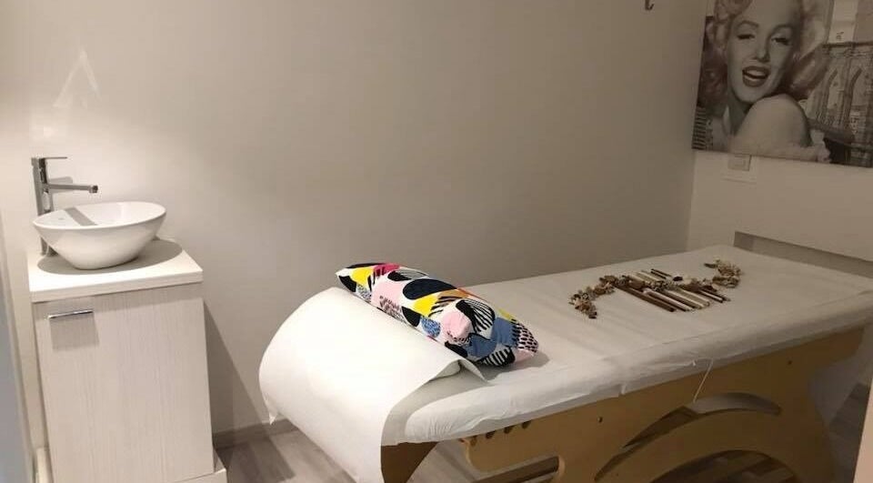 Sala massaggi elegante di Elite a Soave, Veneto, IT, con letto e lavabo moderno.