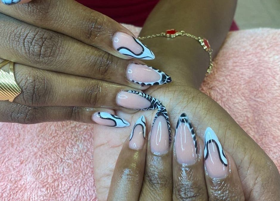 Intricate nail art at The StLucian Goddess Nail Salon in Gros Islet, LC showcasing detailed black and nude designs.