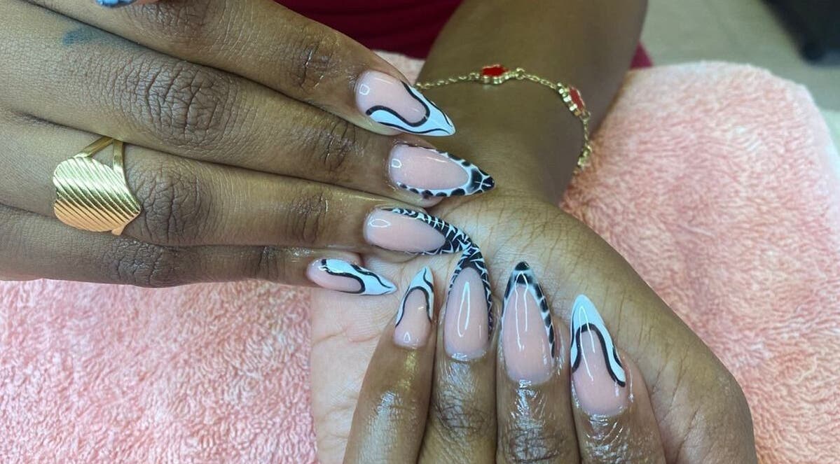 Intricate nail art at The StLucian Goddess Nail Salon in Gros Islet, LC showcasing detailed black and nude designs.