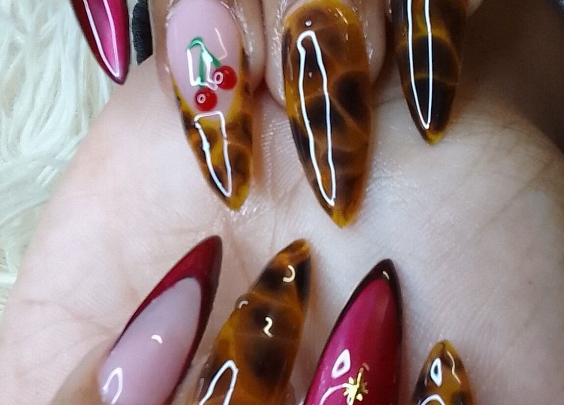 Stylish nail art with cherries at The StLucian Goddess Nail Salon, Gros Islet, LC, offering unique designs.