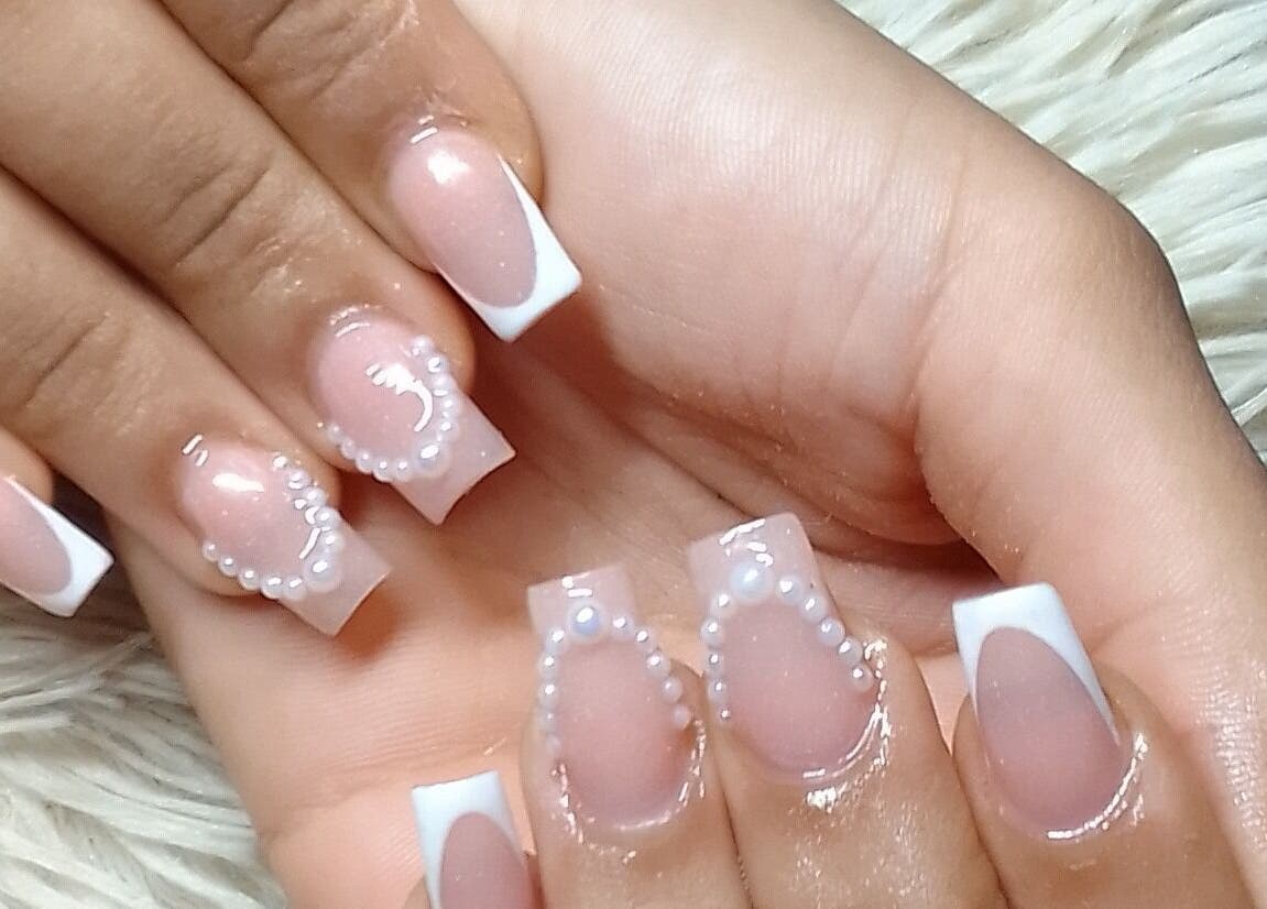 Elegant pearl-accented French manicure at The StLucian Goddess Nail Salon in Gros Islet, LC.