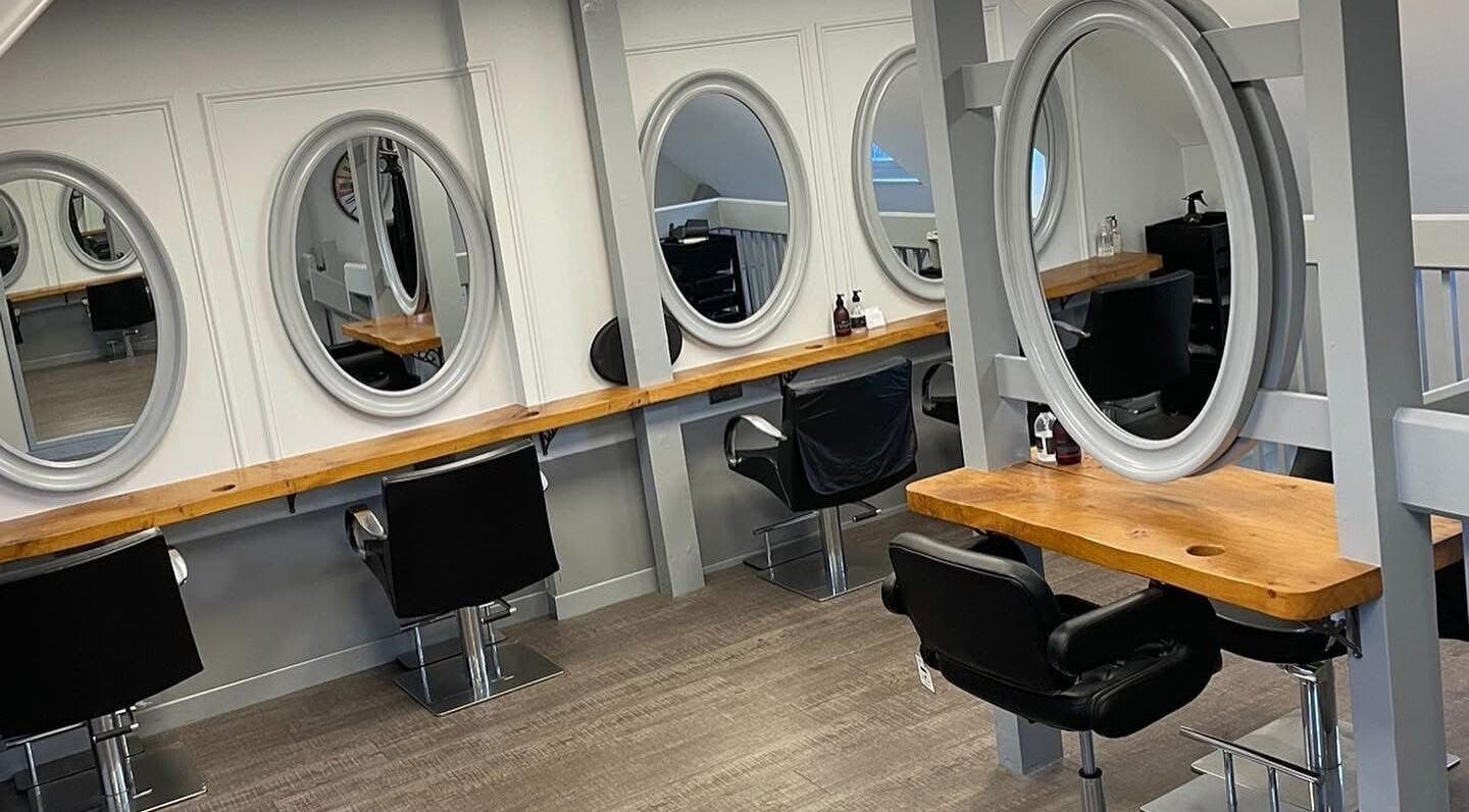 Interior view of Hair by Hannah Milne, Aberdeen, Scotland, GB, showcasing stylish salon workstations.