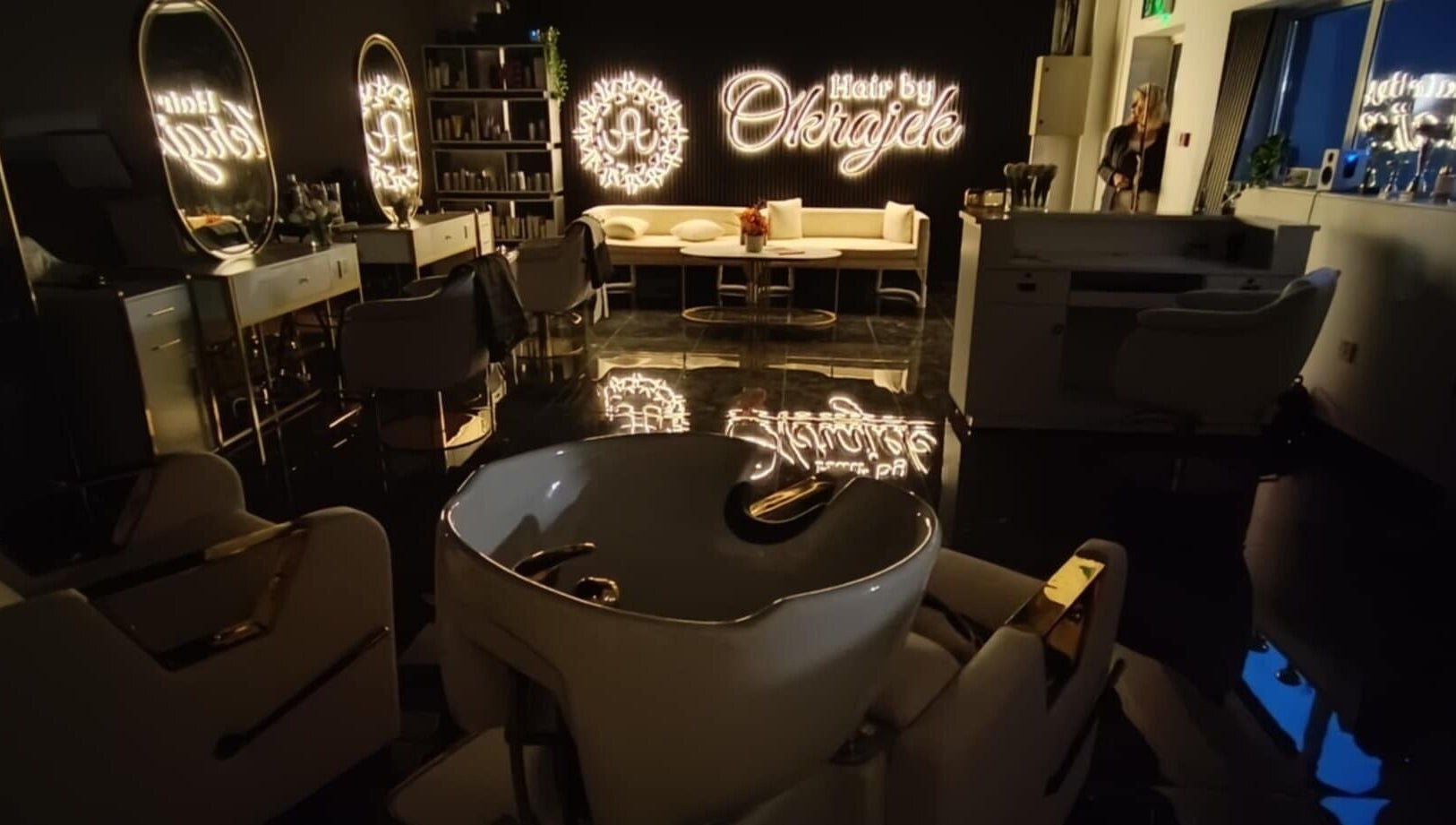 Elegant interior of Hair by Okrajek, Cork, County Cork, IE, featuring chic salon chairs and illuminated decor.