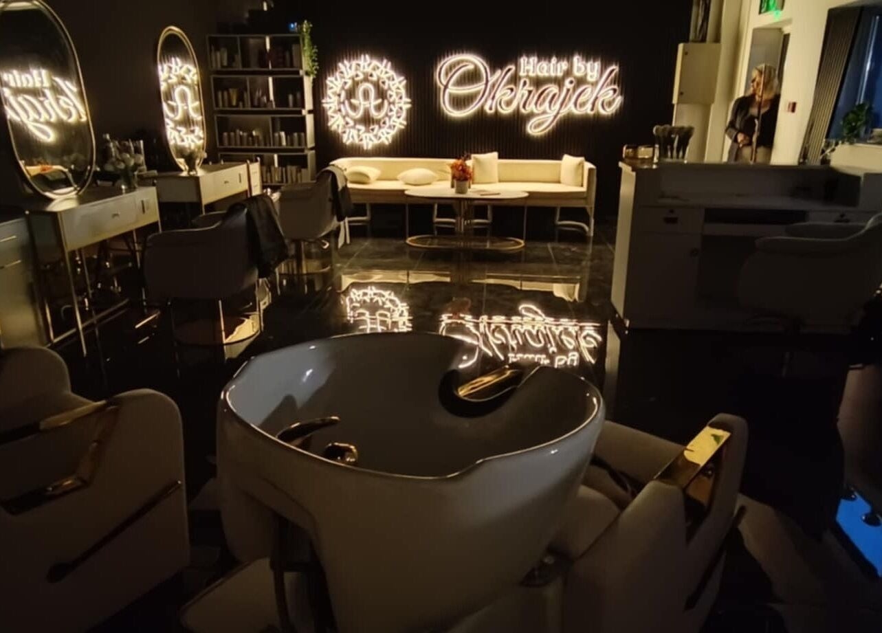 Elegant interior of Hair by Okrajek, Cork, County Cork, IE, featuring chic salon chairs and illuminated decor.