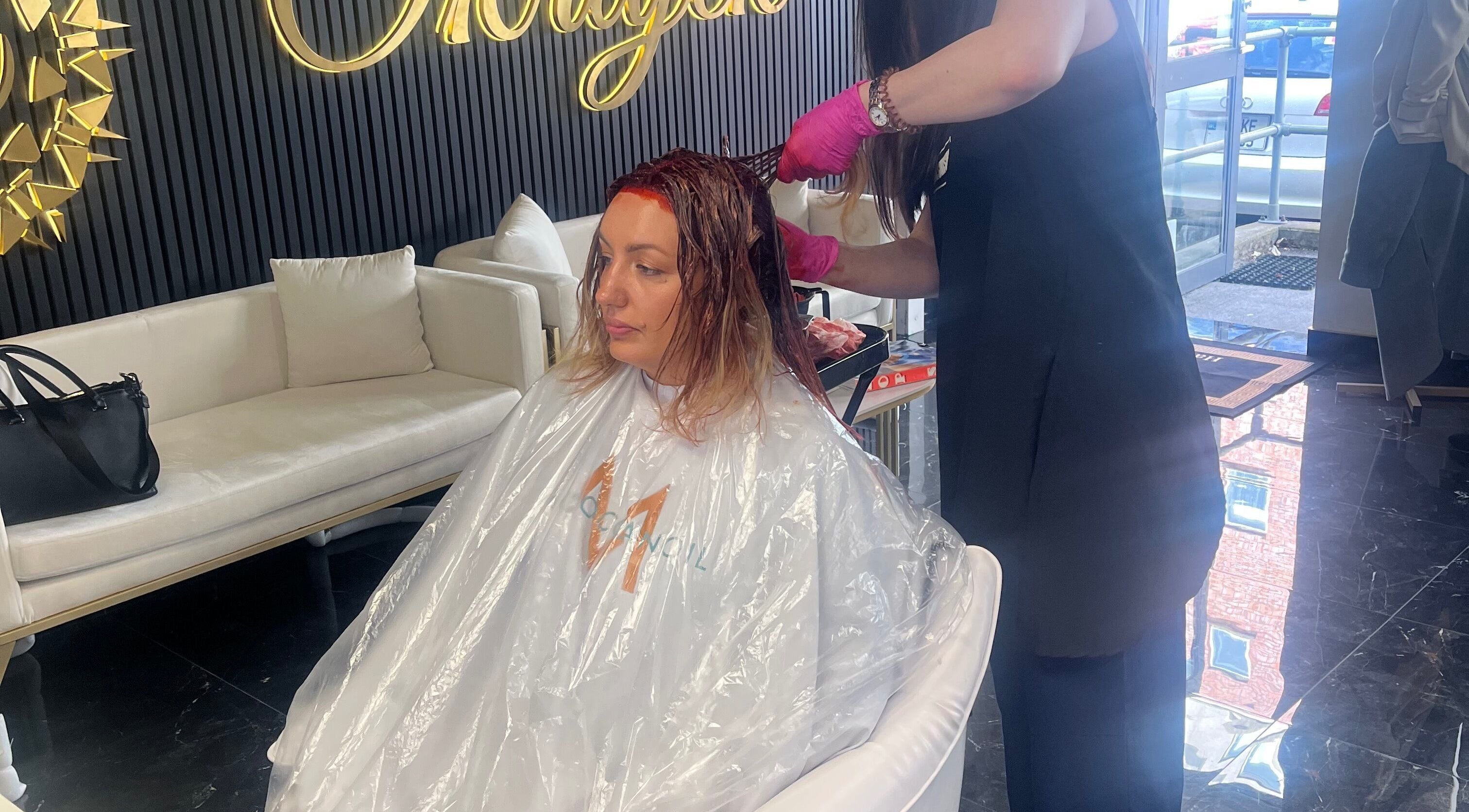 Stylist applying hair color at Hair by Okrajek, Cork, County Cork, IE.