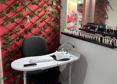 Stylish nail station at Nifty Lash and Beauty, Hamilton, Waikato, NZ with an elegant red backdrop.