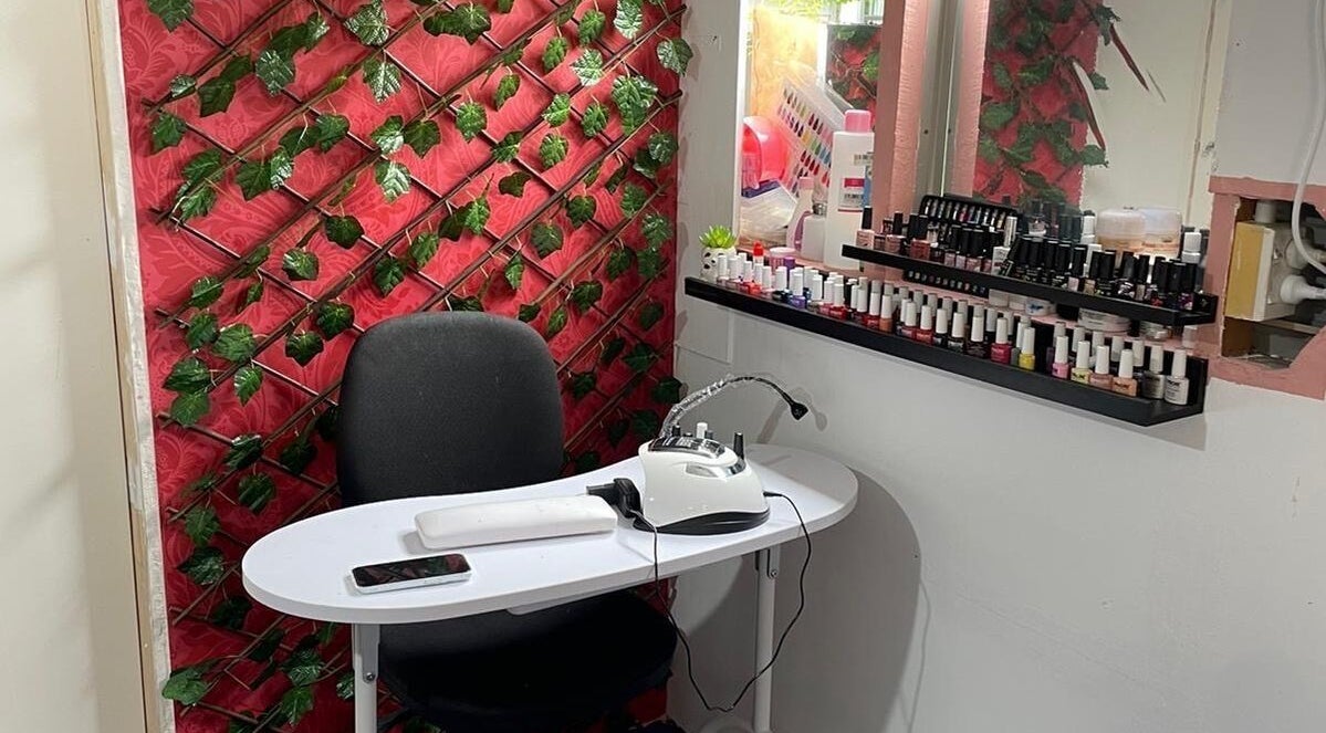 Stylish nail station at Nifty Lash and Beauty, Hamilton, Waikato, NZ with an elegant red backdrop.