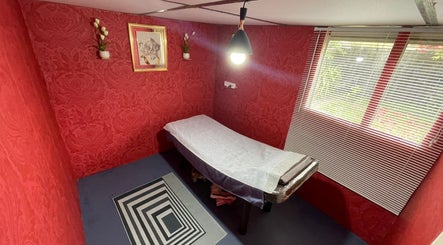 Tranquil treatment room at Nifty Lash and Beauty, Hamilton, Waikato, NZ with elegant red decor.